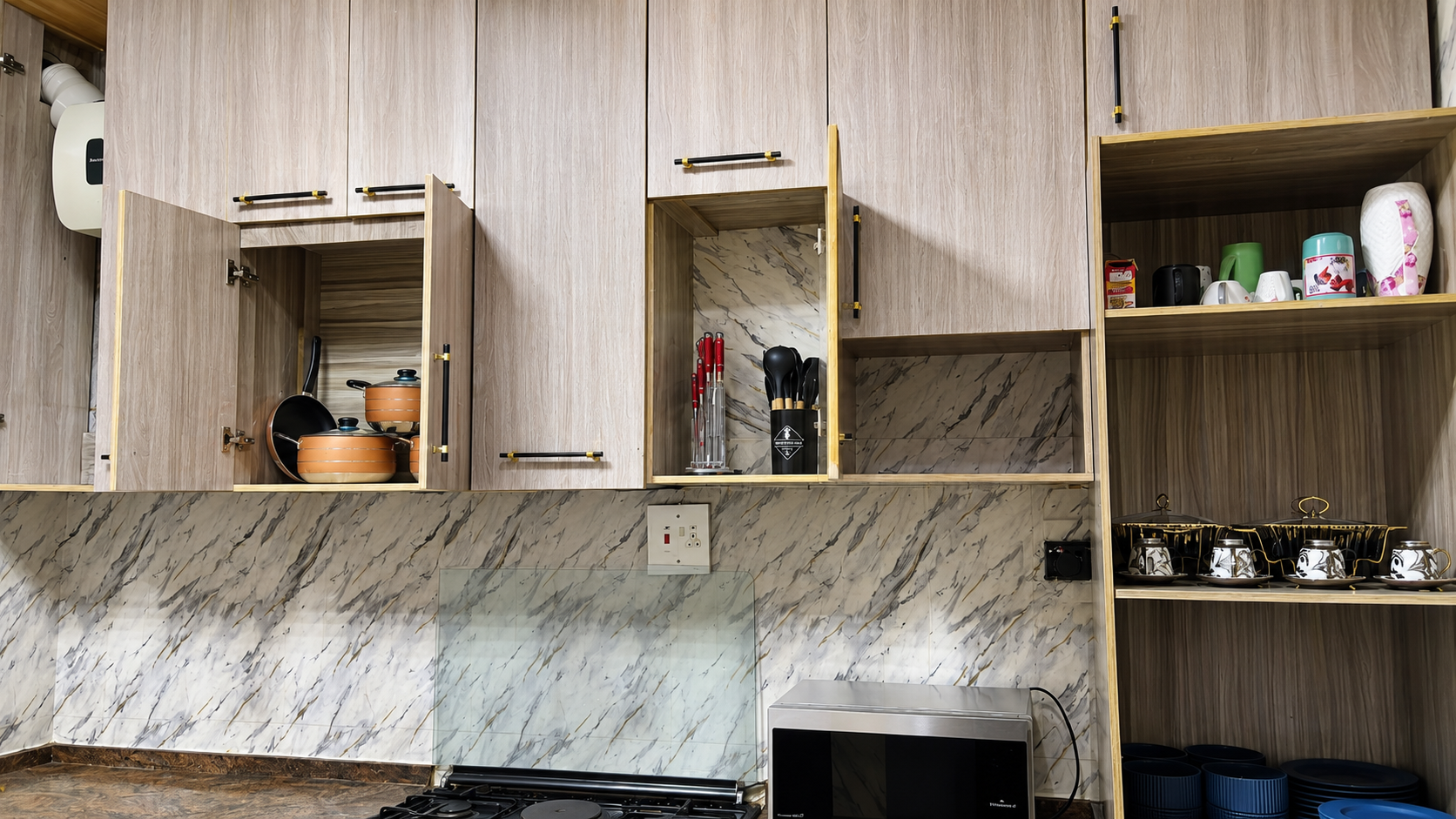 Gold 7 Residence kitchen cabinets with cookware, utensils and dining ware